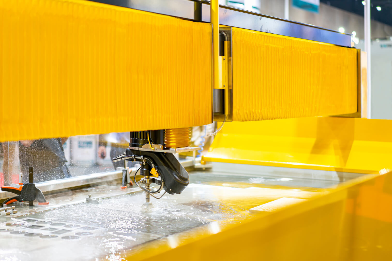 close up seat nozzle of precision automatic cnc high speed & pressure water jet cutting machine during manufacturing process cut stone or metal sheet of industrial work